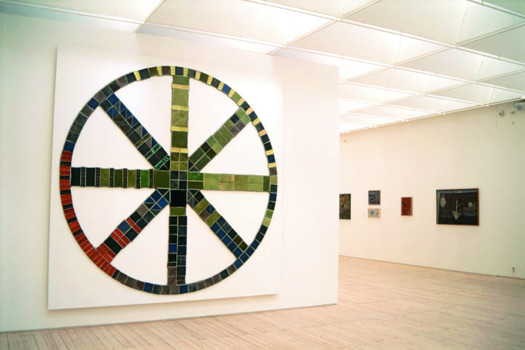 Ett verk av Anders Österlin hänger på en vägg, föreställande en stor cirkel med diagonala streck i.
