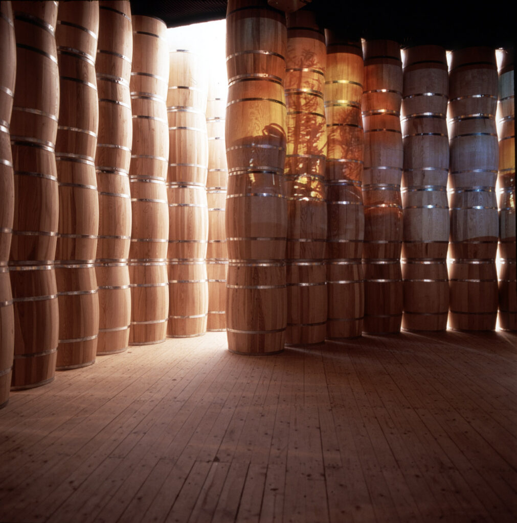 Insidan av installation av Lena Mattson – en stor mängd trätunnor står staplade på varandra i rader och bildar ett runt rum.