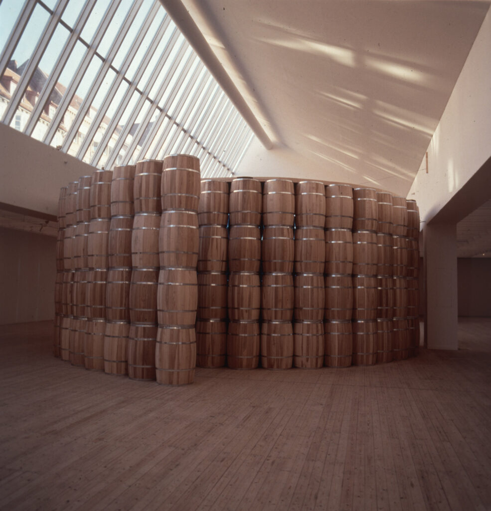 Installation av Lena Mattson – en stor mängd trätunnor står staplade på varandra i rader för att bilda ett runt rum i Malmö Konsthalls ljusschakt.