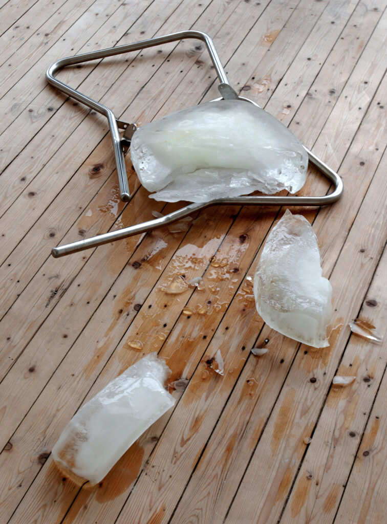 Verk av Jana Sterbak. Metallrör och stora bitar av is ligger på trägolvet i Konsthallen.