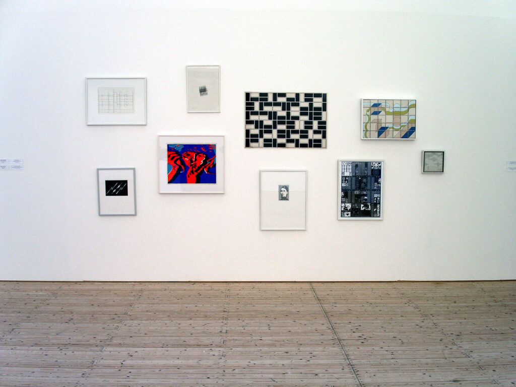 Installationsbild/vy av utställningen Electrohype 2004. Olika grafiska verk hänger inramade på en vägg i konsthallen.