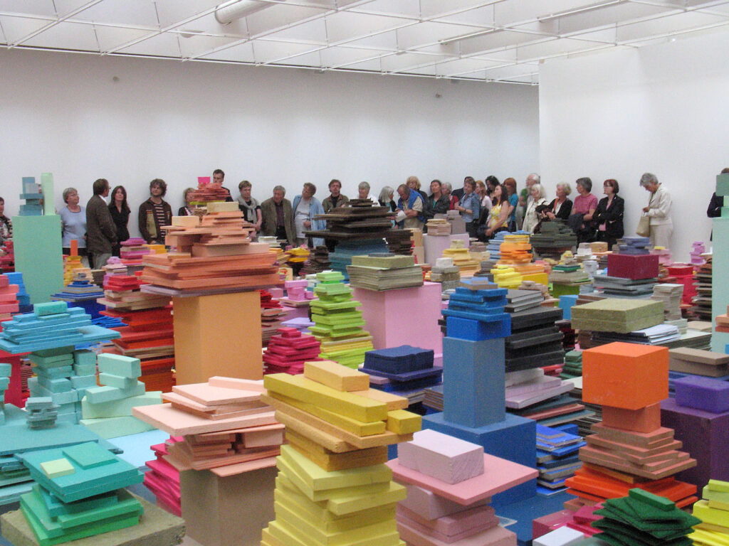 Ett rum fyllt med staplade högar med färgstarka träplattor.