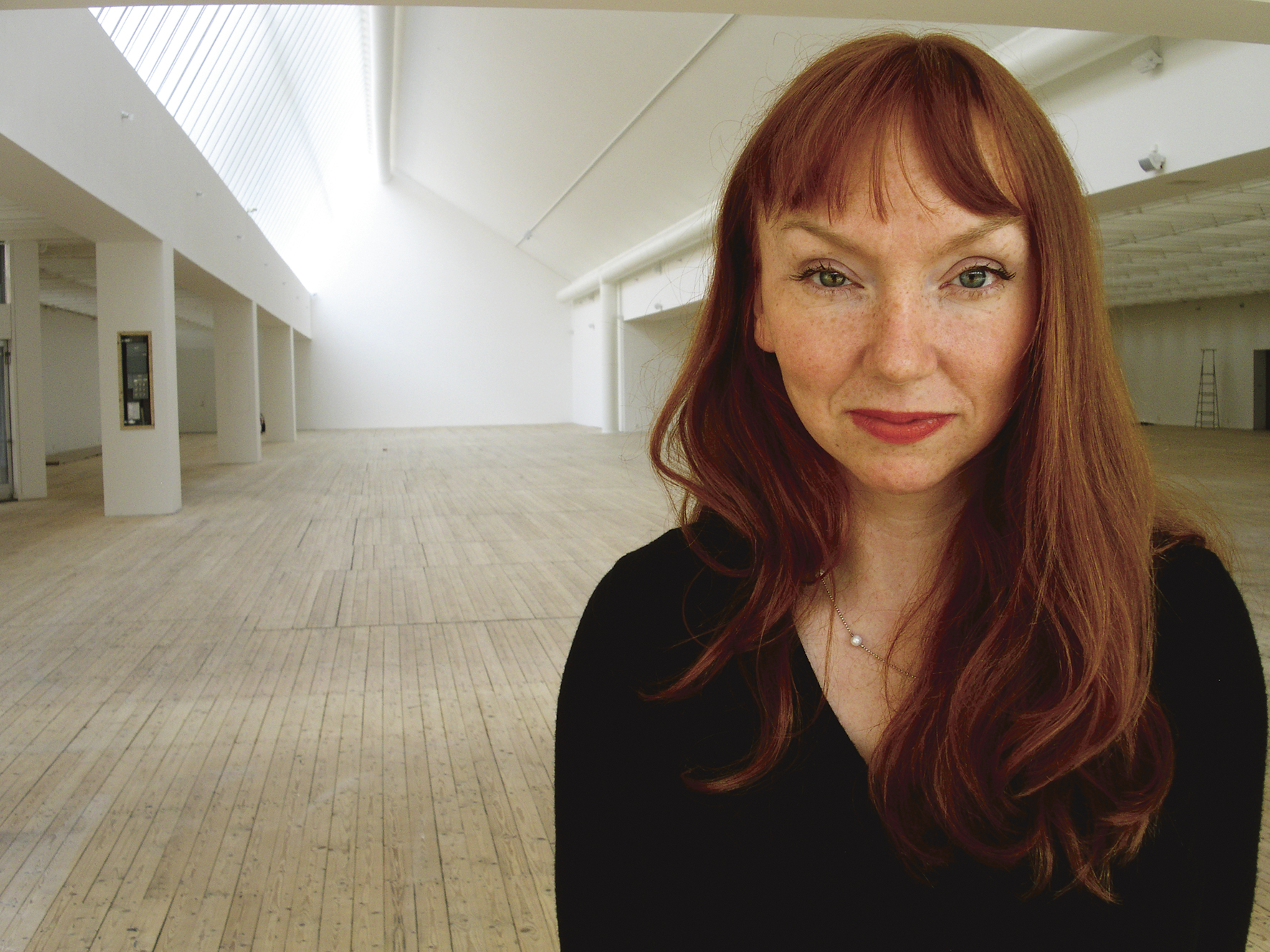 Portrait of Susan Philipsz standing in the art gallery's skylight.