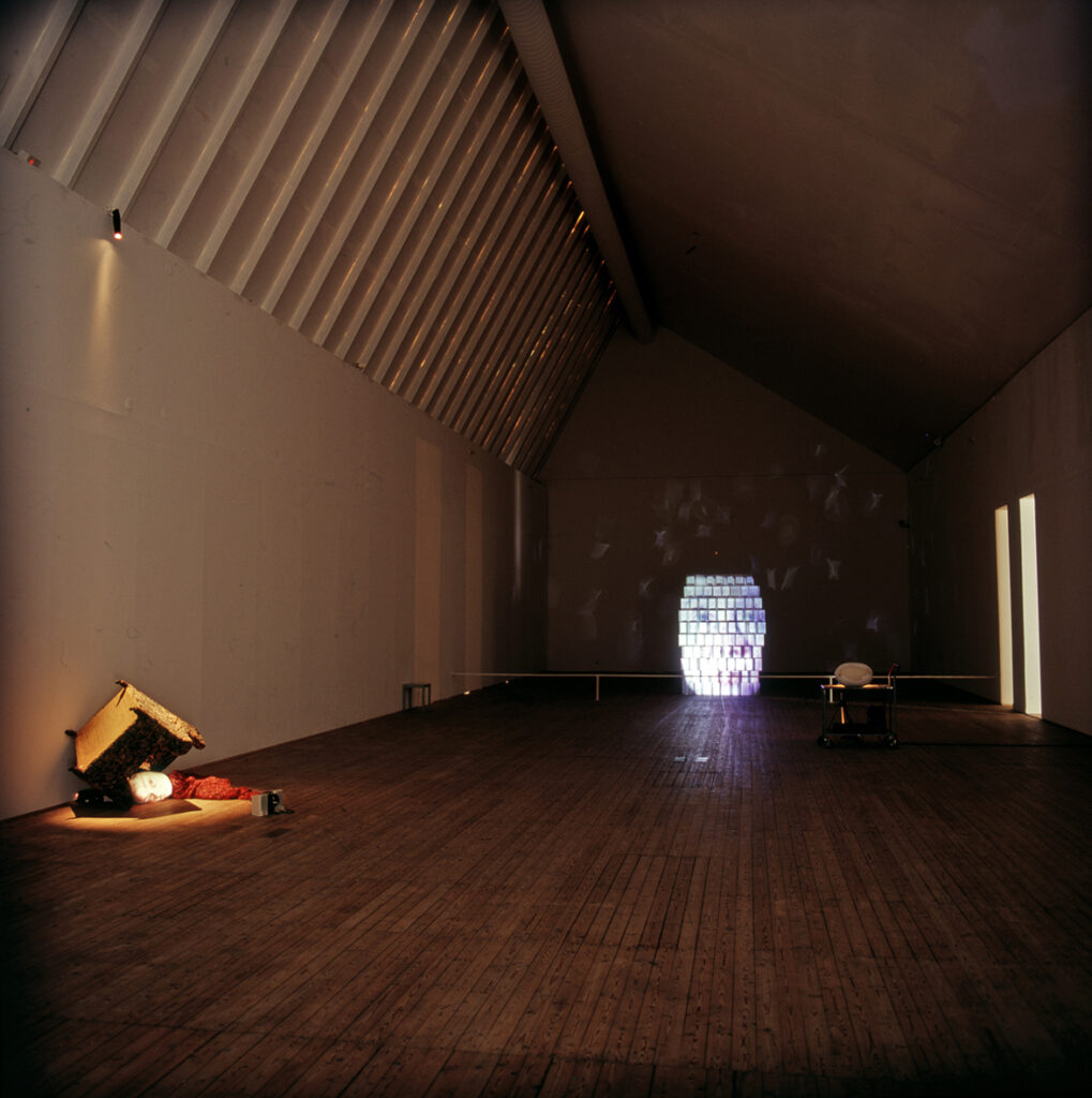 En mörk konsthall som lyses upp av Tony Ourslers varsamt utspridda ljusverk