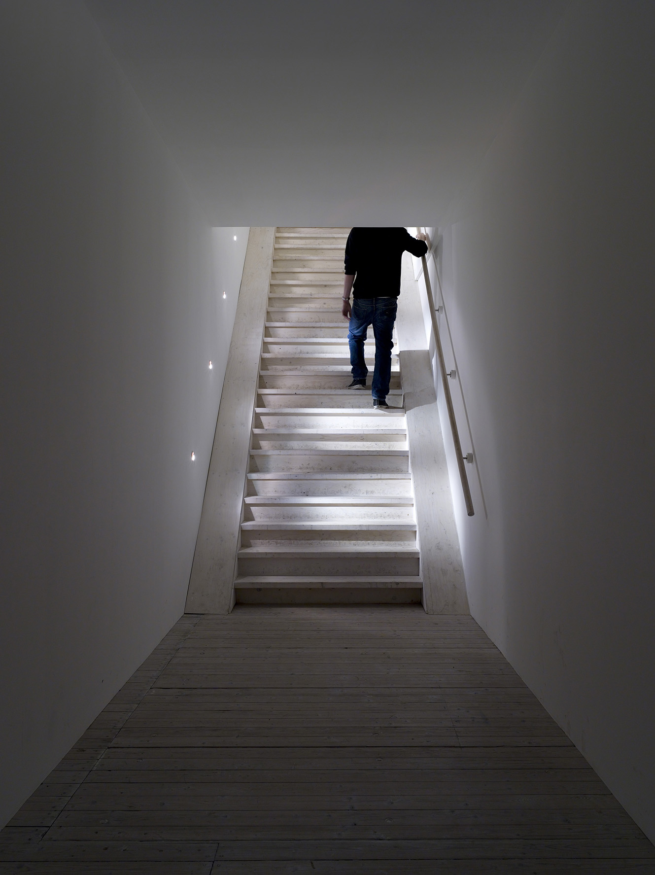 Installation av Elmgreen och Dragset. En man går upp för en trätrappa, längst in i ett smalt rum.