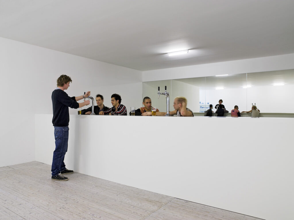 Installation av Elmgreen och Dragset. En man serverar öl till fyra män som hänger i en bar.