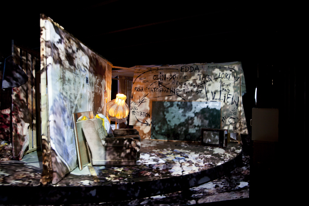 Installationsbild av utställningen The Alien within, 2014. Ett mörkt rum med en rund roterande scenografi är fragmenterat belyst av en projektion.