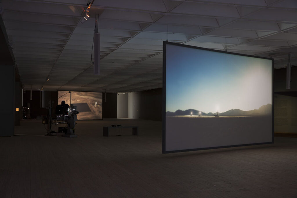 Film projeceras på stora dukar i ett mörklagt rum.