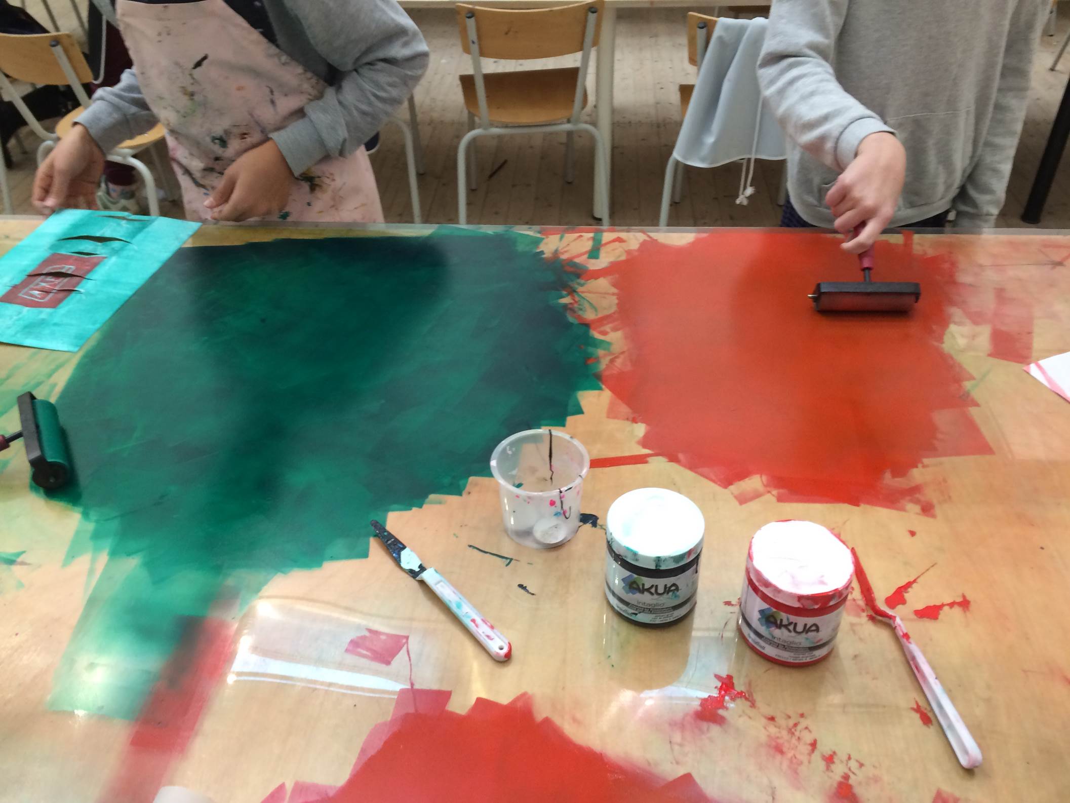 Två barn målar i starka färger direkt på bord