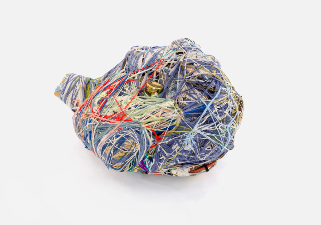 Artwork by Judith Scott made of yarn and thread spun into an organic, multicolored form.