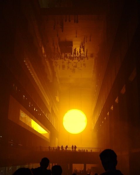 Människor blickar över en artificiell sol som lyser starkt gult
