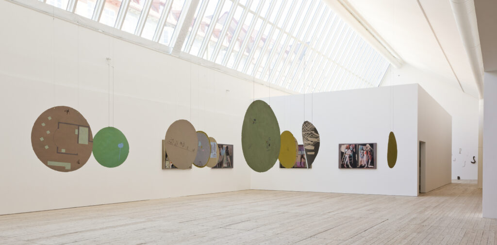 Round paper artworks are hanging in the bright art gallery.