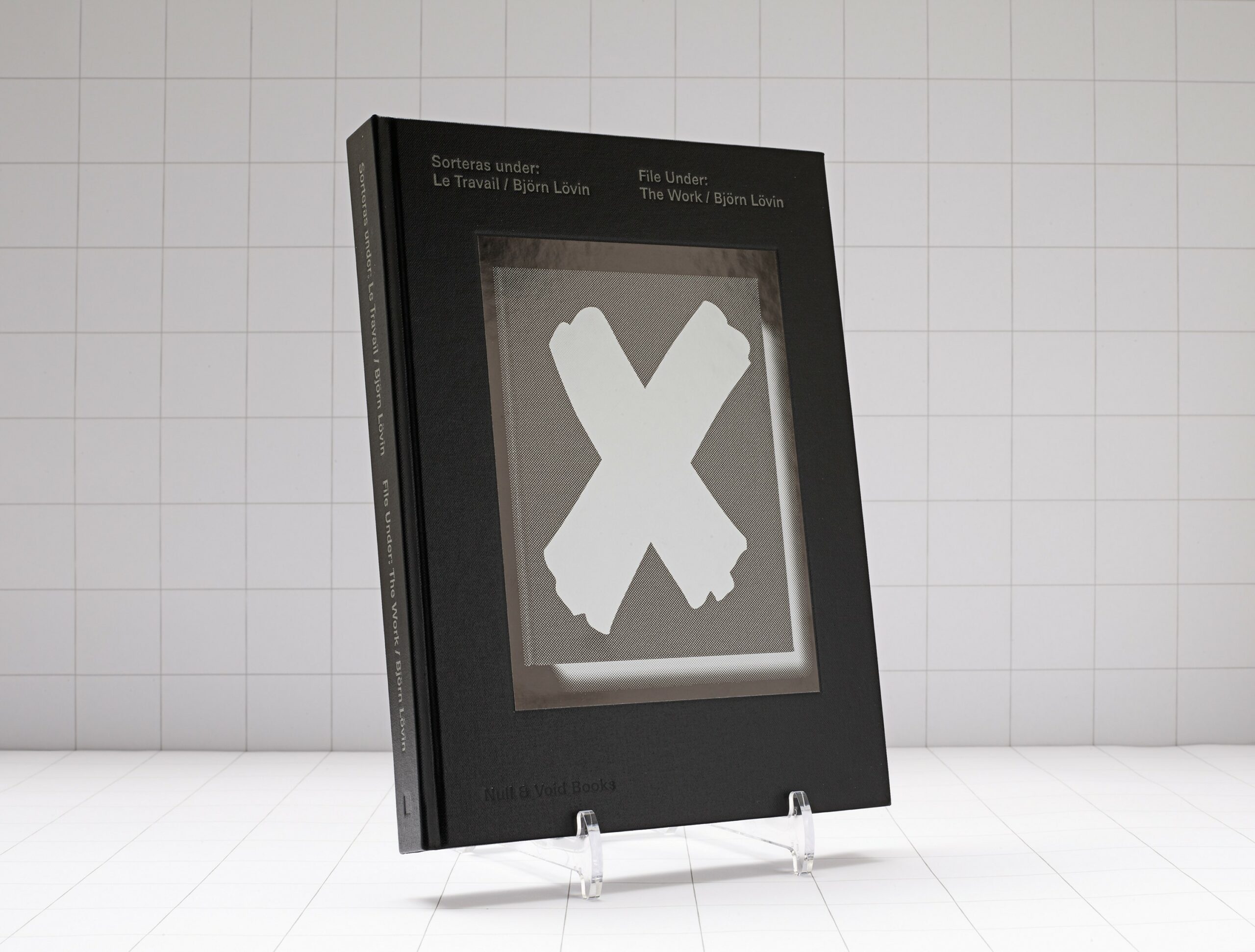 Svart bok med vitt X ståendes i vitt rum