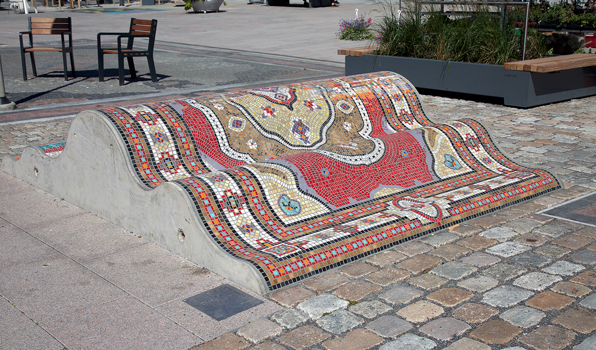 Betong klädd i färgglad mosaik ute i stad