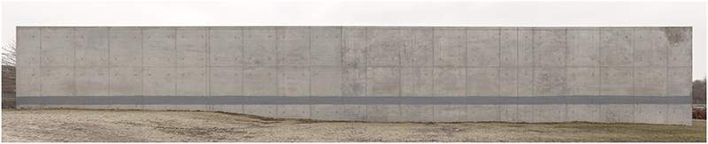 Långsmal bild av betongvägg. På betonväggen är ett långt grått streck målat.