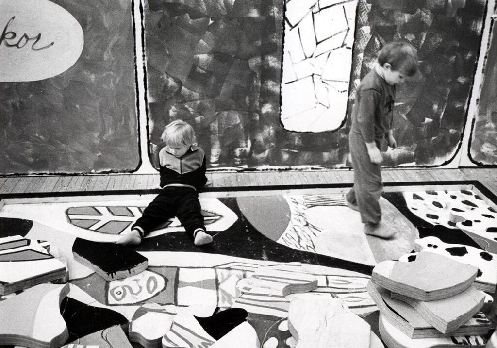 Black and white image of children playing in an exhibition. 