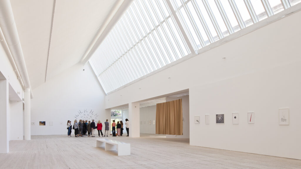 En grupp med personer på guidad visning i konsthallens hissnande ljusschakt