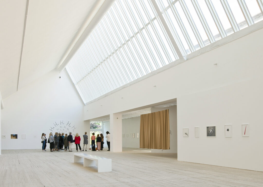 A group of people on a guided tour in the art gallery's breathtaking light shafts.