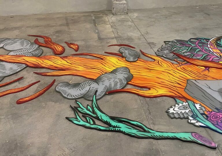 Målning av eldslågor på betonggolv av Kim Demåne.