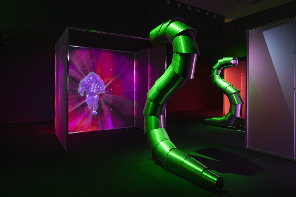 Image of a sculpture surrounded by green and pink light