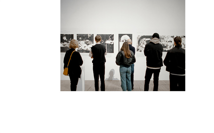 Bild tagen bakifrån på en rad personer som tittar på Åke Hodells konstverk på väggen i konsthallen.