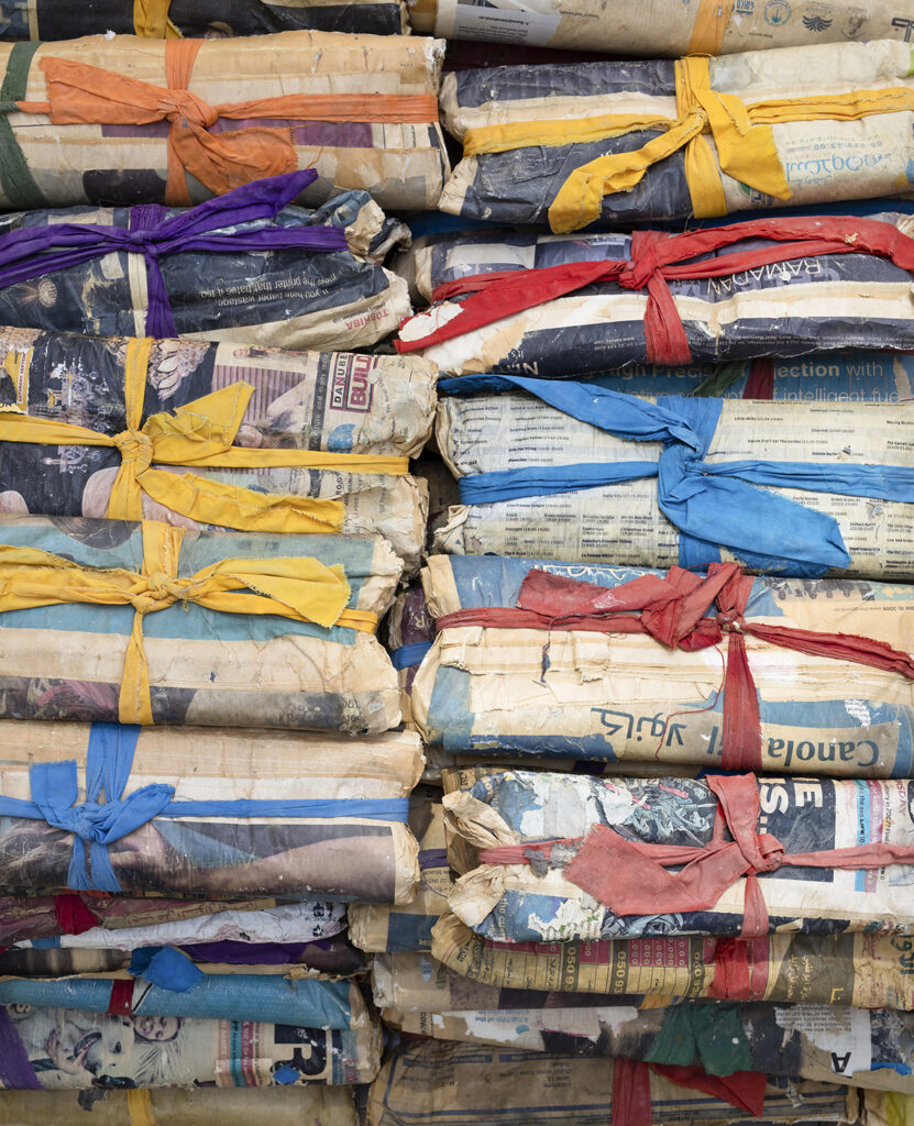 Old newspapers bundled together with colorful fabric ribbons, resembling wrapped gifts.