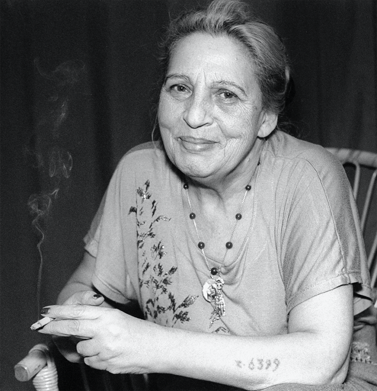 Svartvitt porträtt av Ceoja stojka som ler mjukt. På hennes arm ser man siffrorna från koncentrationslägret tatuerade