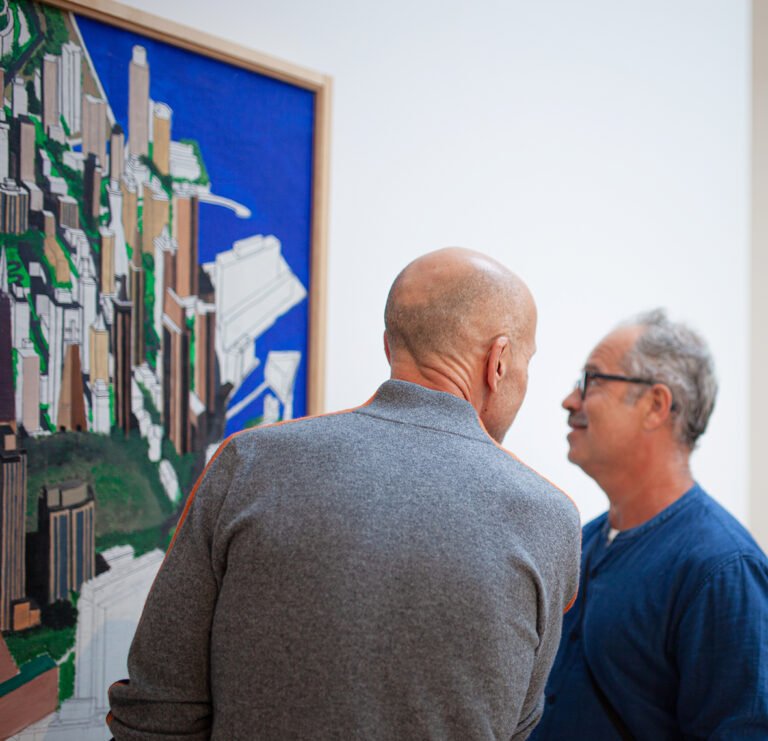 Två män tittar på en färgglad målning tillsammans