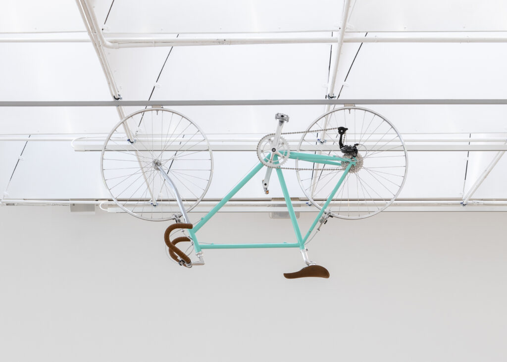 En uppochnervänd cykel som hänger i taket i konsthallen