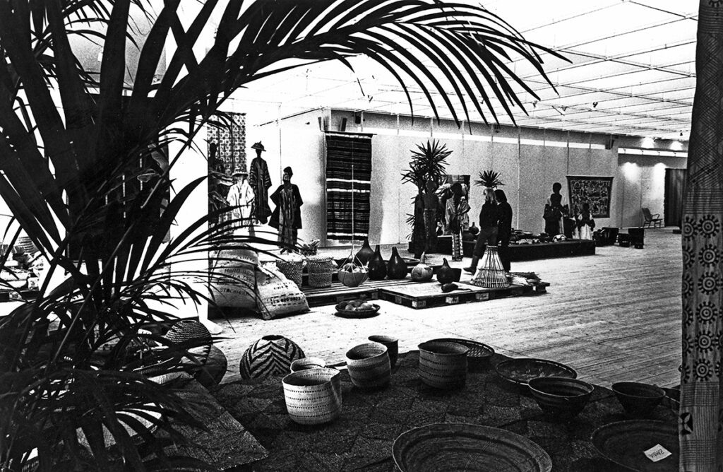 En stor palm i förgrunde, Konsthallen är fylld av afrikanska korgar, krukor och textilier.