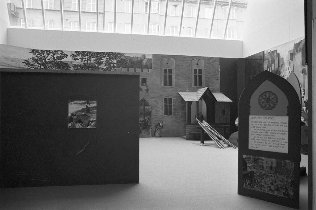 Utställningshallen från utställningen Leka med Bruegel. Miljöbilder från ett slottsliv är uppsatta på väggen.
