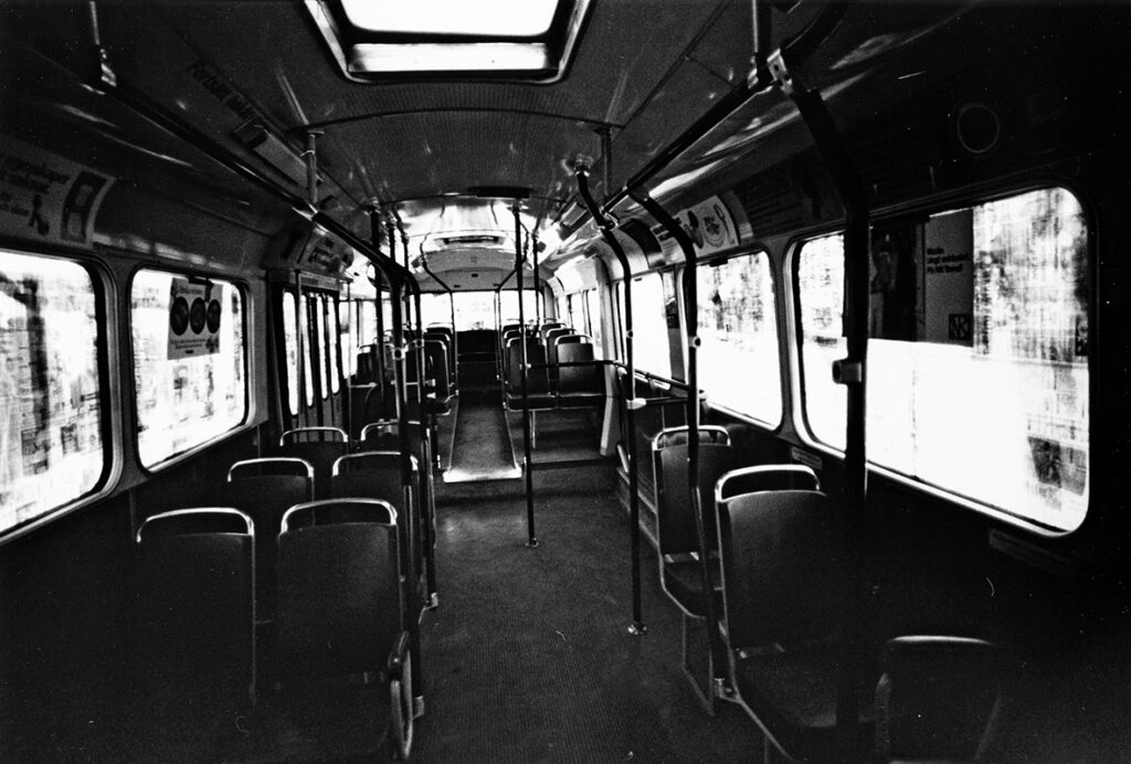 En buss fotograferad inifrån. Fönsterna är täckta med tidningspapper.
