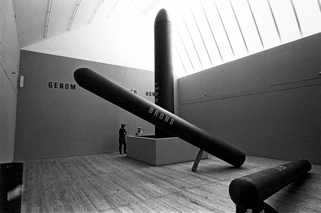 Giganstiska mörka skulpturer som påminner om missiler tronar i hallen. Man skymtar ord på verken och väggarna så som brons, järn mm.