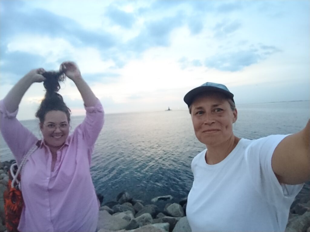 Selfie av unga kvinnor som ler, med havet som bakgrund