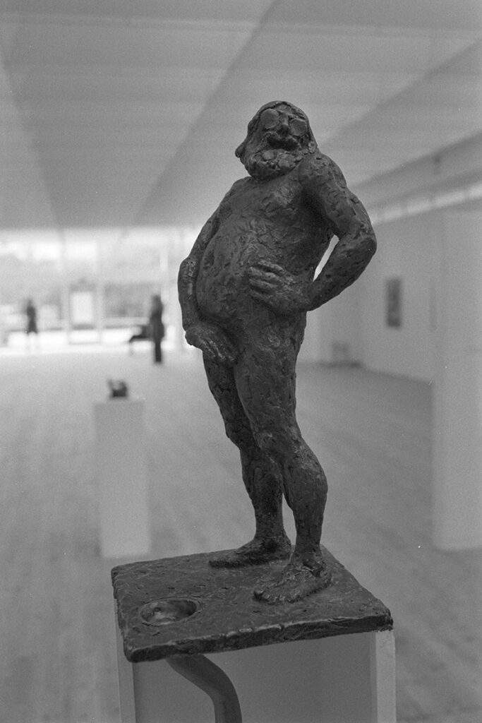 En skulptur som avbildat en tjock man som står naken och täcker sitt skrev med sin hand.