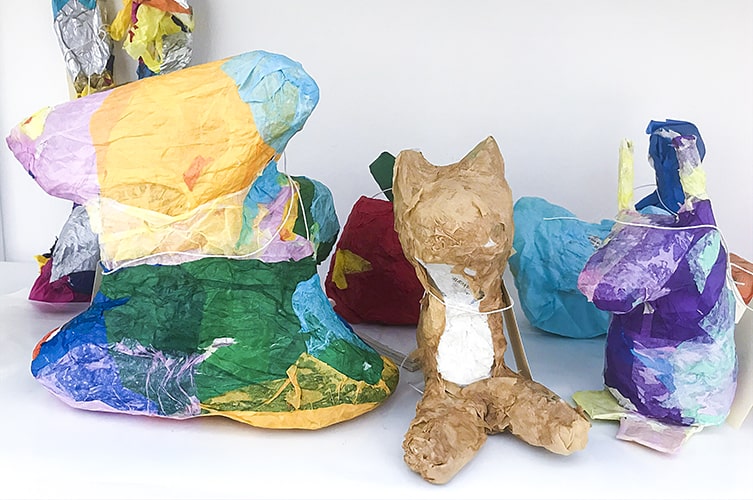Flera färgglada verk i materialet papier maché föreställande bl.a. en räv och en fågel