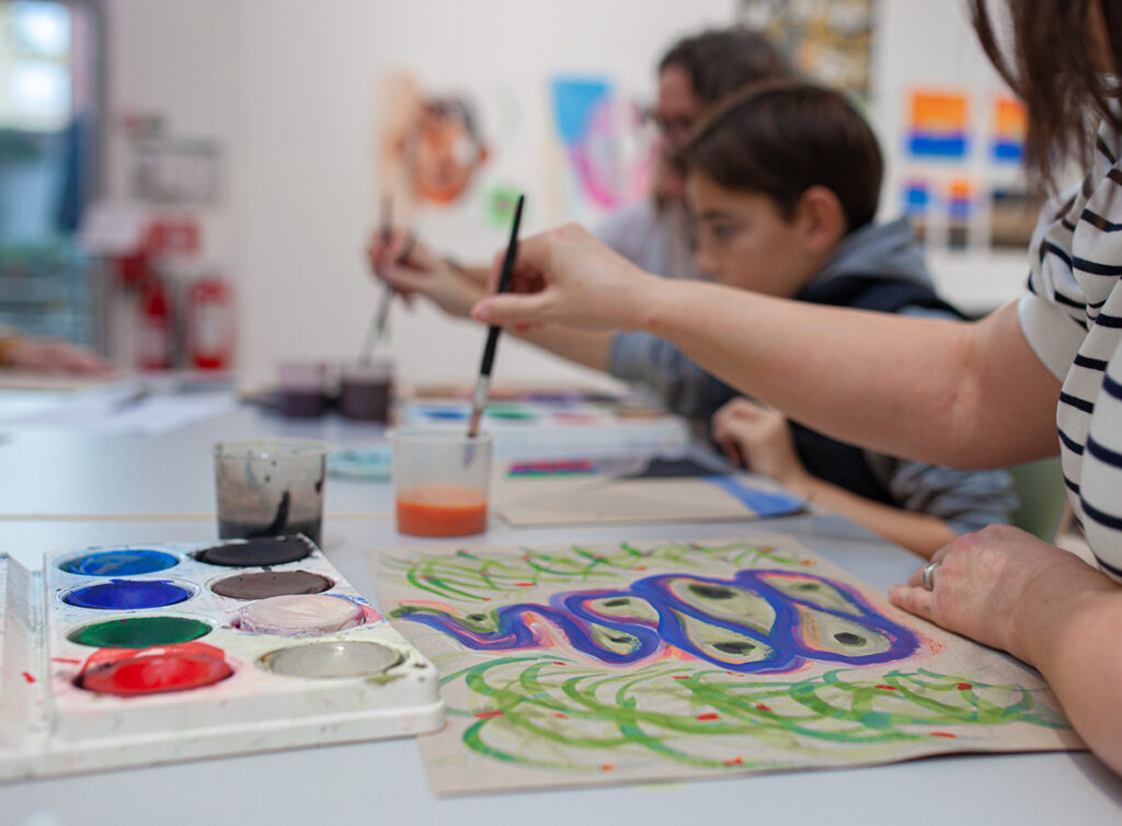 A family sits and make art in the workshop.