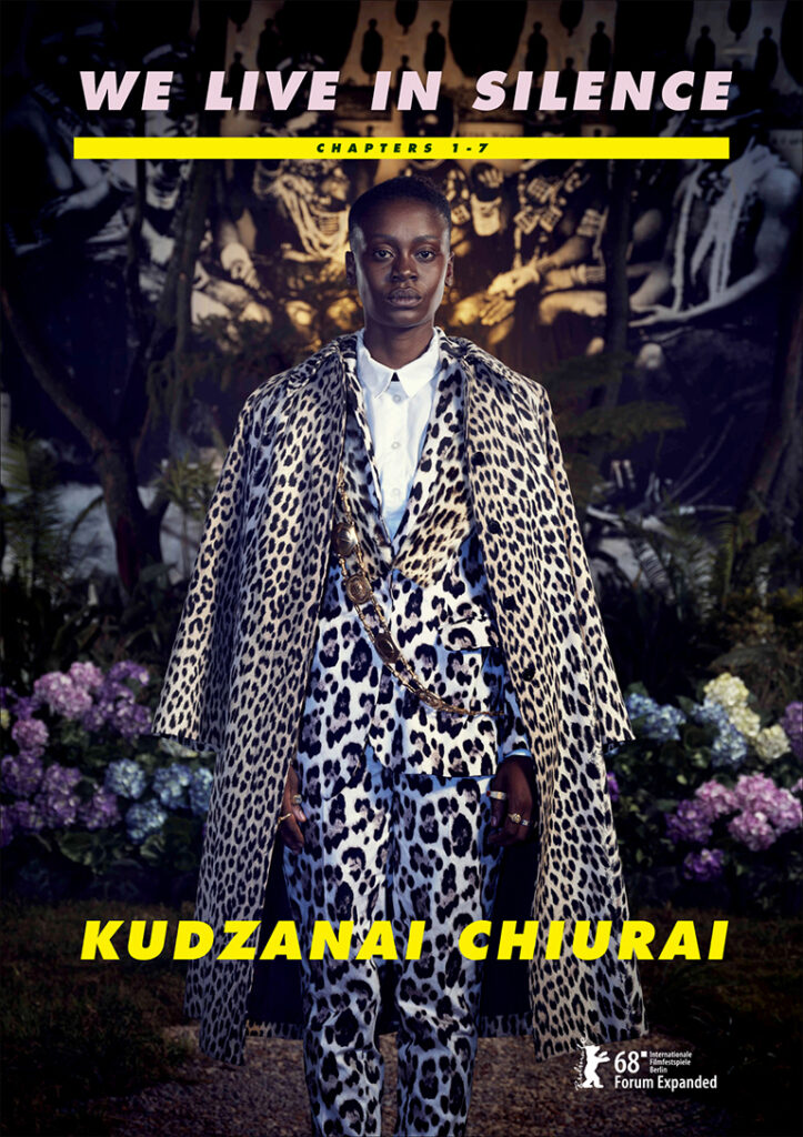 Woman dressed in a leopard-patterned suit and coat in front of flowers and dark patterns.