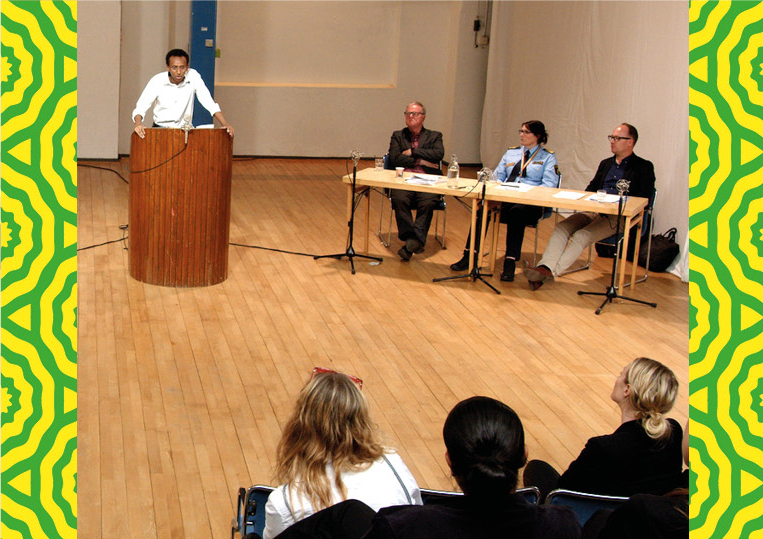 A staged legal forum where a person stands in the lectern and speaks before a collection of lawyers, police officers and judges.