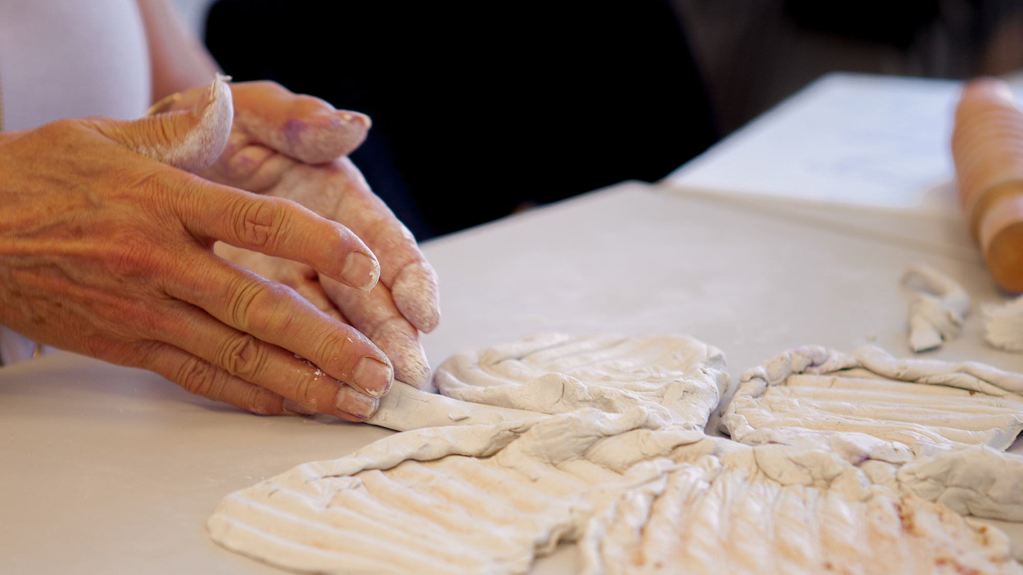 Close-up of a pair of hands working with clay.