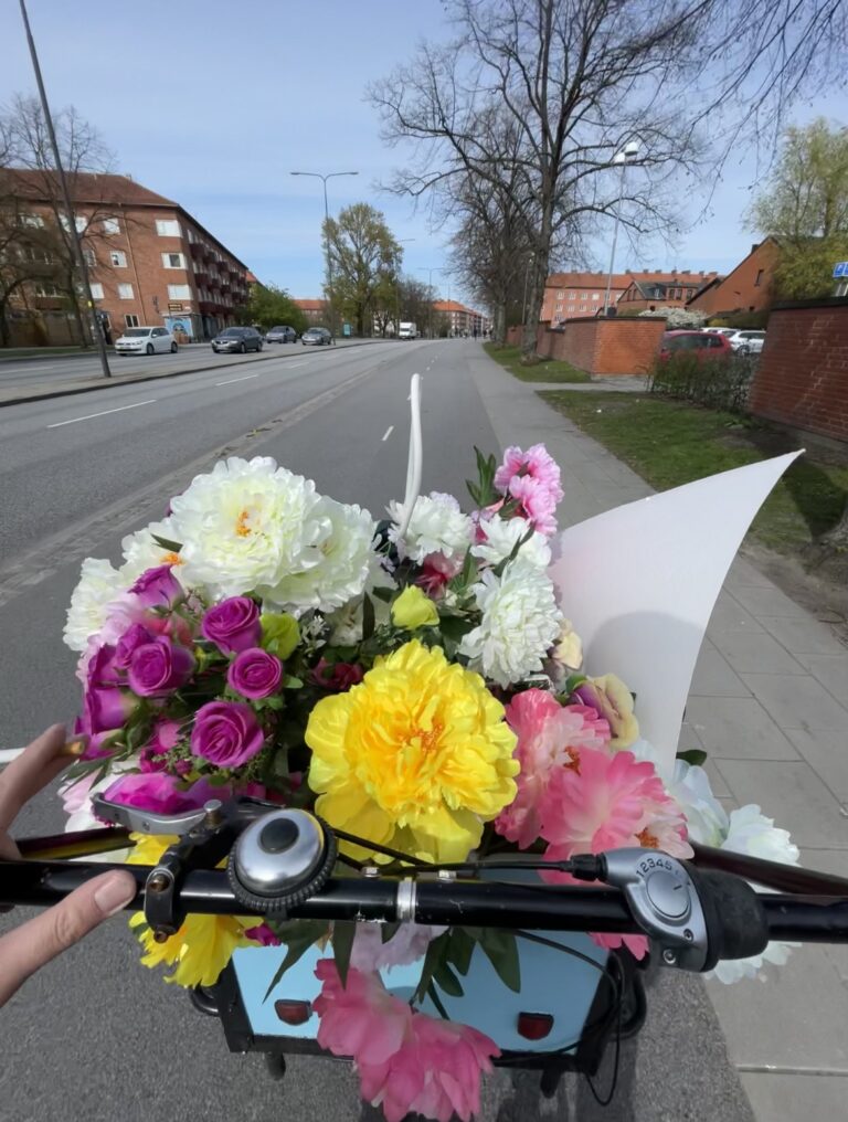 En cykelkorg med en stor, färgglad blombukett.