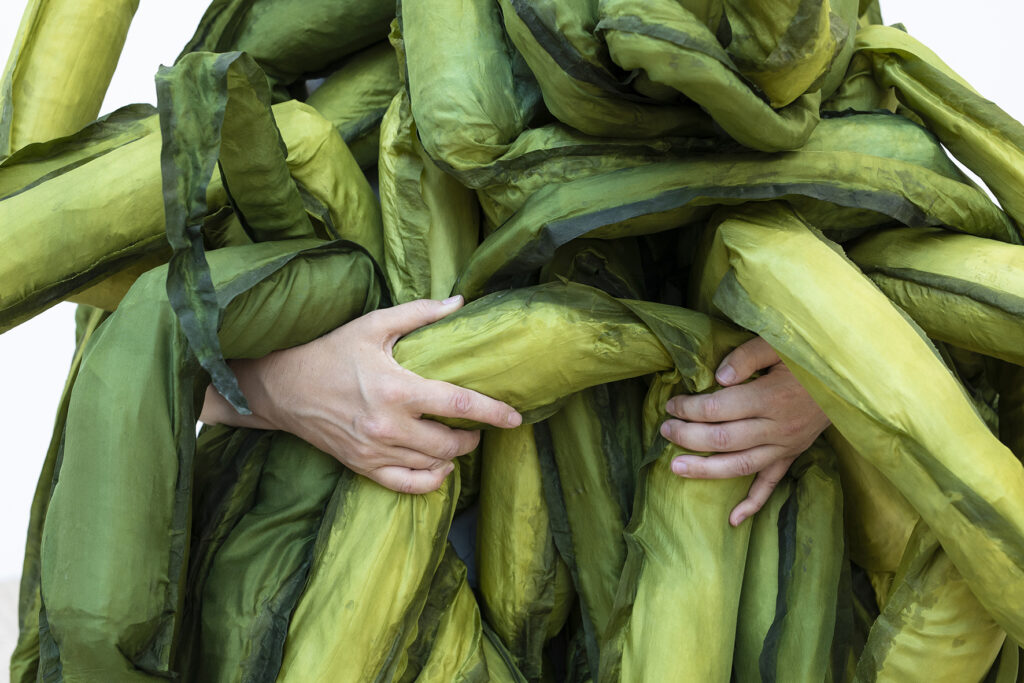 Two hands holding a large robe representing tongs.