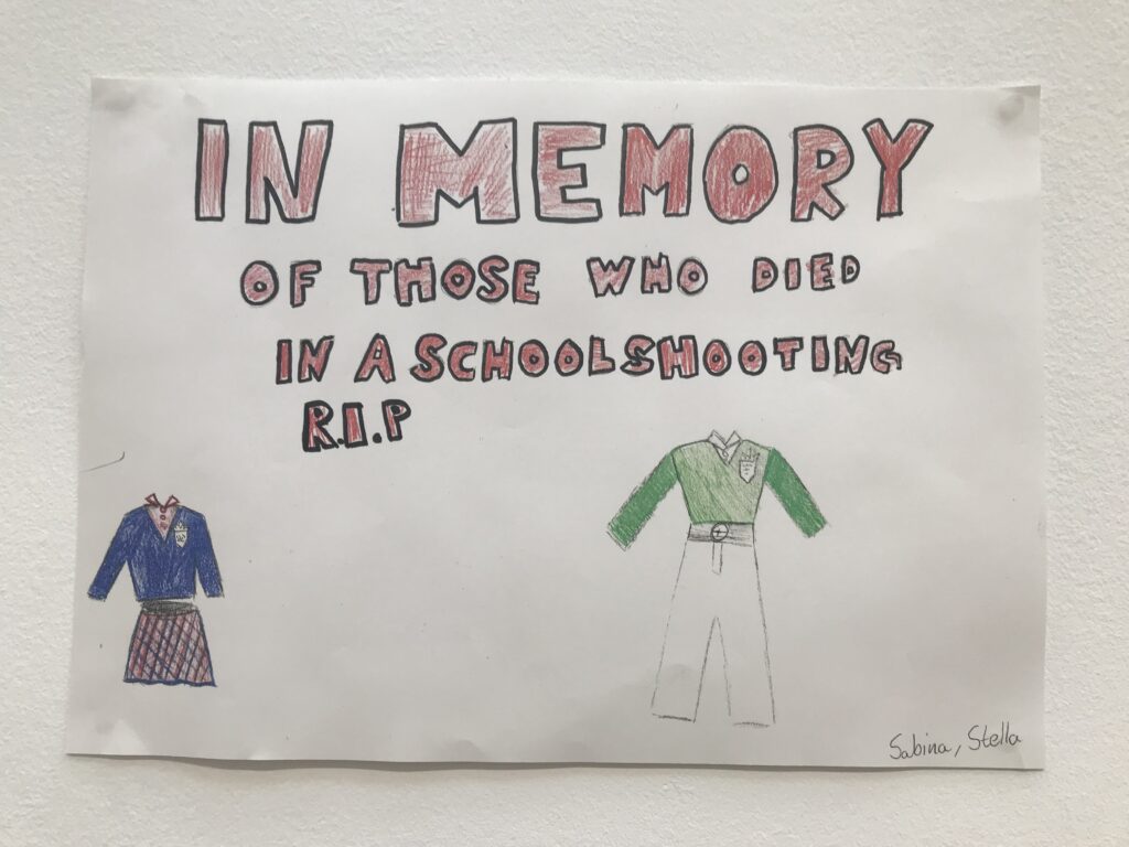 Teckning med texten “In memory of those who died in a school shooting R.I.P” och två ritade skoluniformer.