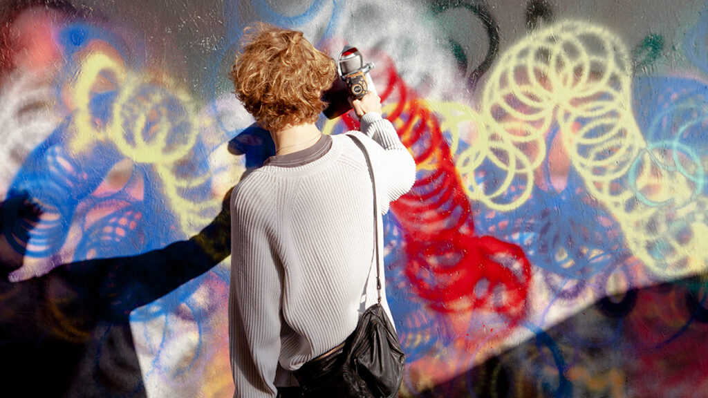 En inspirerande bild av en ung person som målar ett plank i solen med en sprayburk.