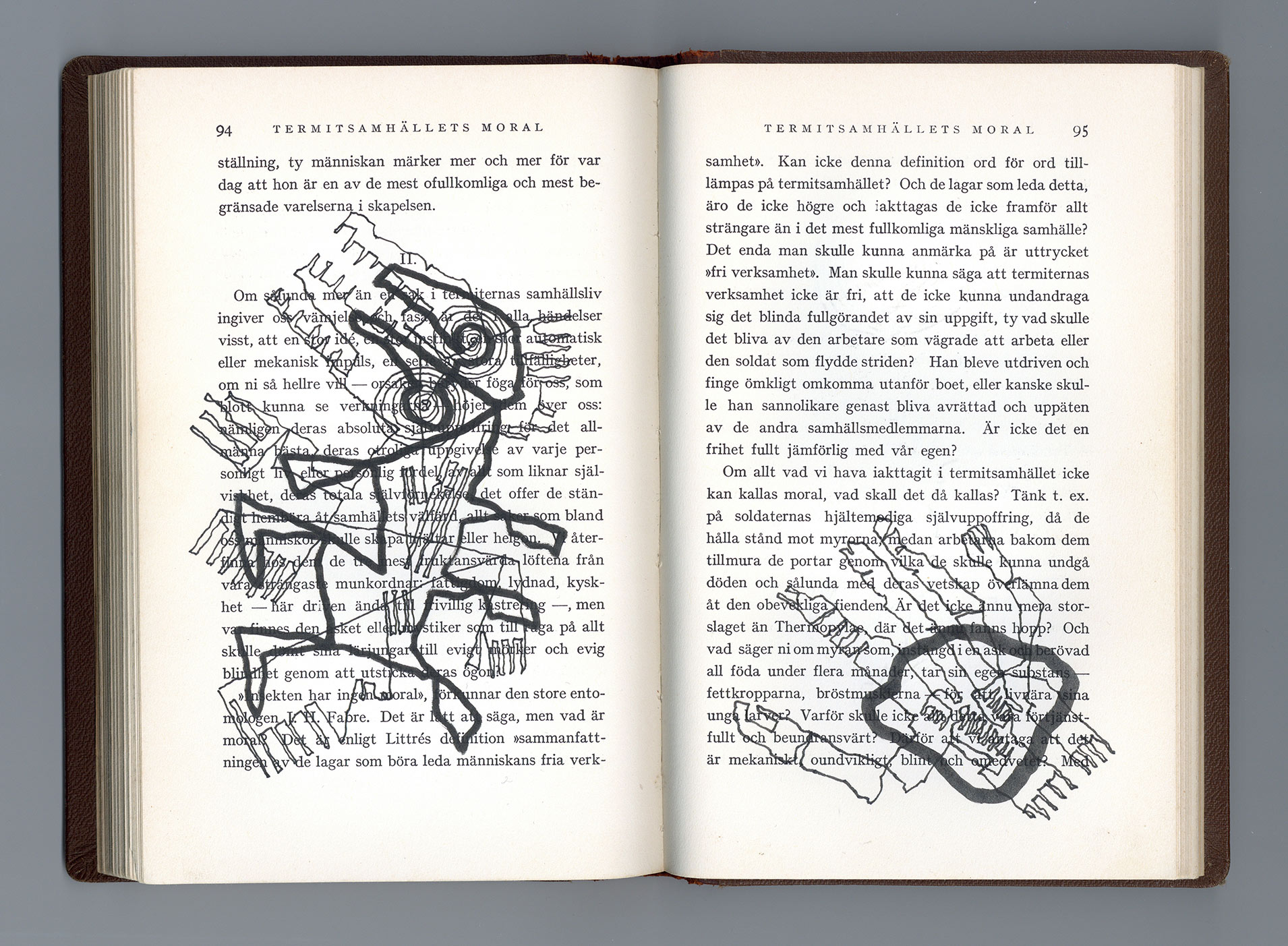 Ett öppet uppslag i en bok med illustrationer i svart över textsidorna.