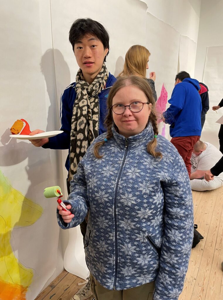 Two people are standing with their artworks in the workshop at Malmö Konsthall.