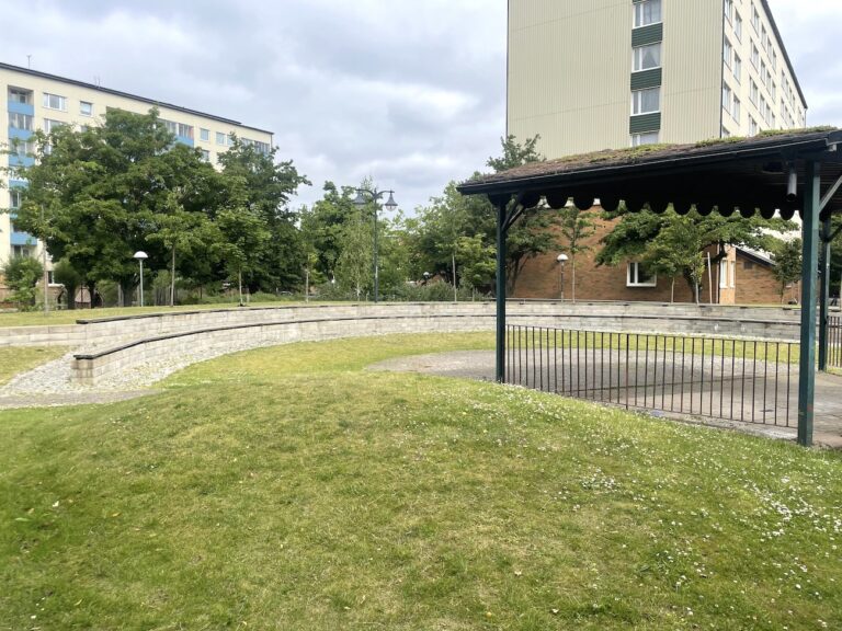 Ett öde bostadsområde med två höghus och ett litet grönområde.