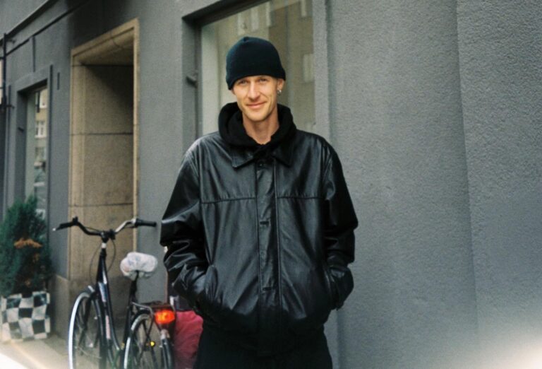 Porträtt av Tom Botwid från Poetic Collective fotograferad utomhus i höstlig miljö iklädd svart läderjacka och svart beanie-mössa.