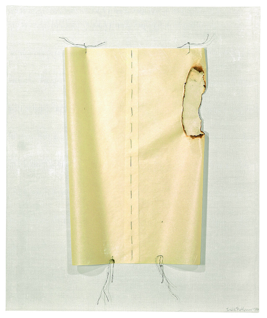 Light yellow textile with handmade, subtle seams in black and a burnt hole in one sida. 