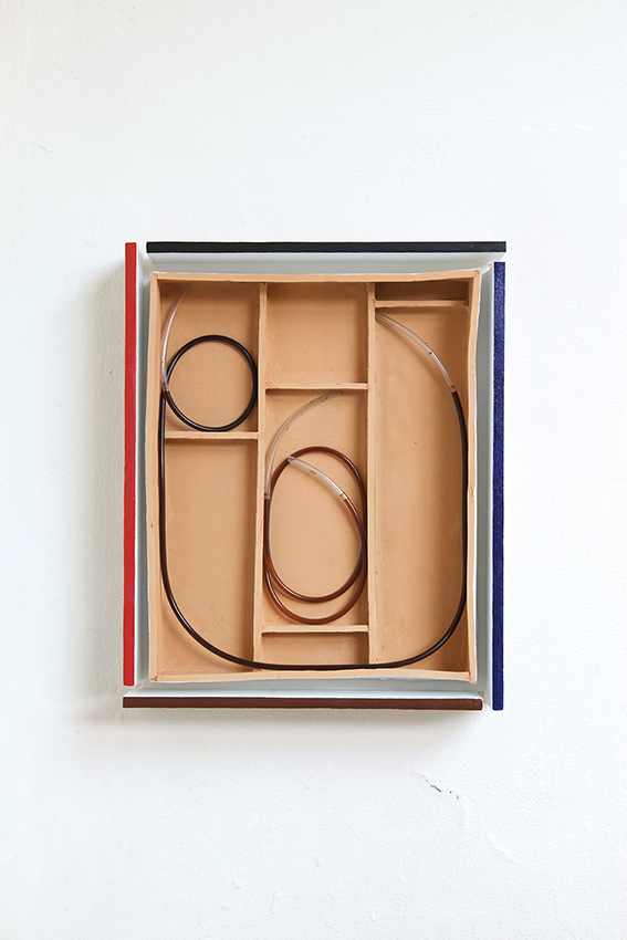 An artwork by Andreas Ronholt Schmidt & Sebastian Hedevang – a framed box-like structure with coffee-filled tubes.